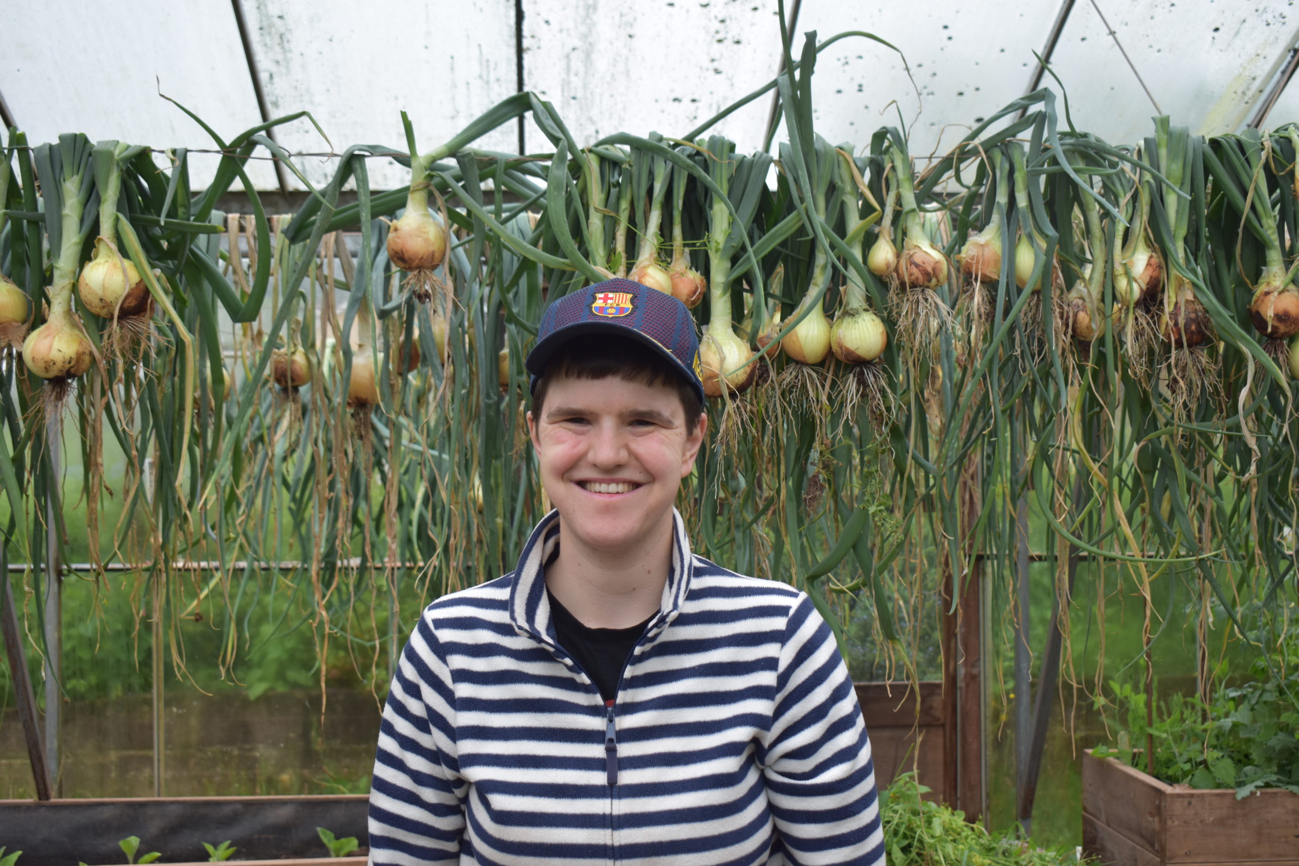 A person we support standing in a greenhouse