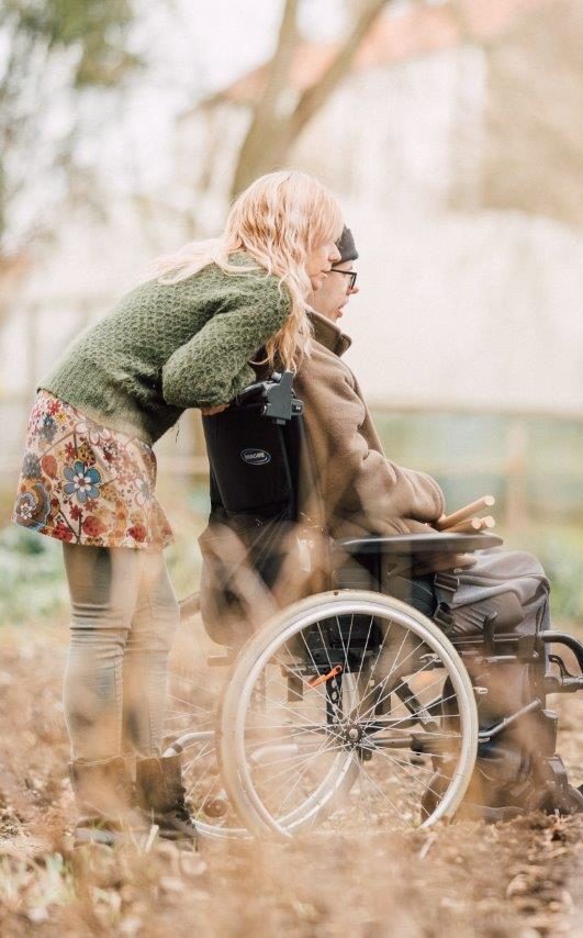 A person we support and staff member outside in the garden