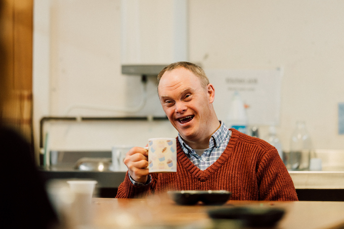 A person drinking coffee and smiling