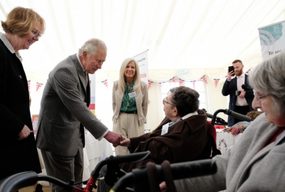 Community members shaking hands with King Charles at an event