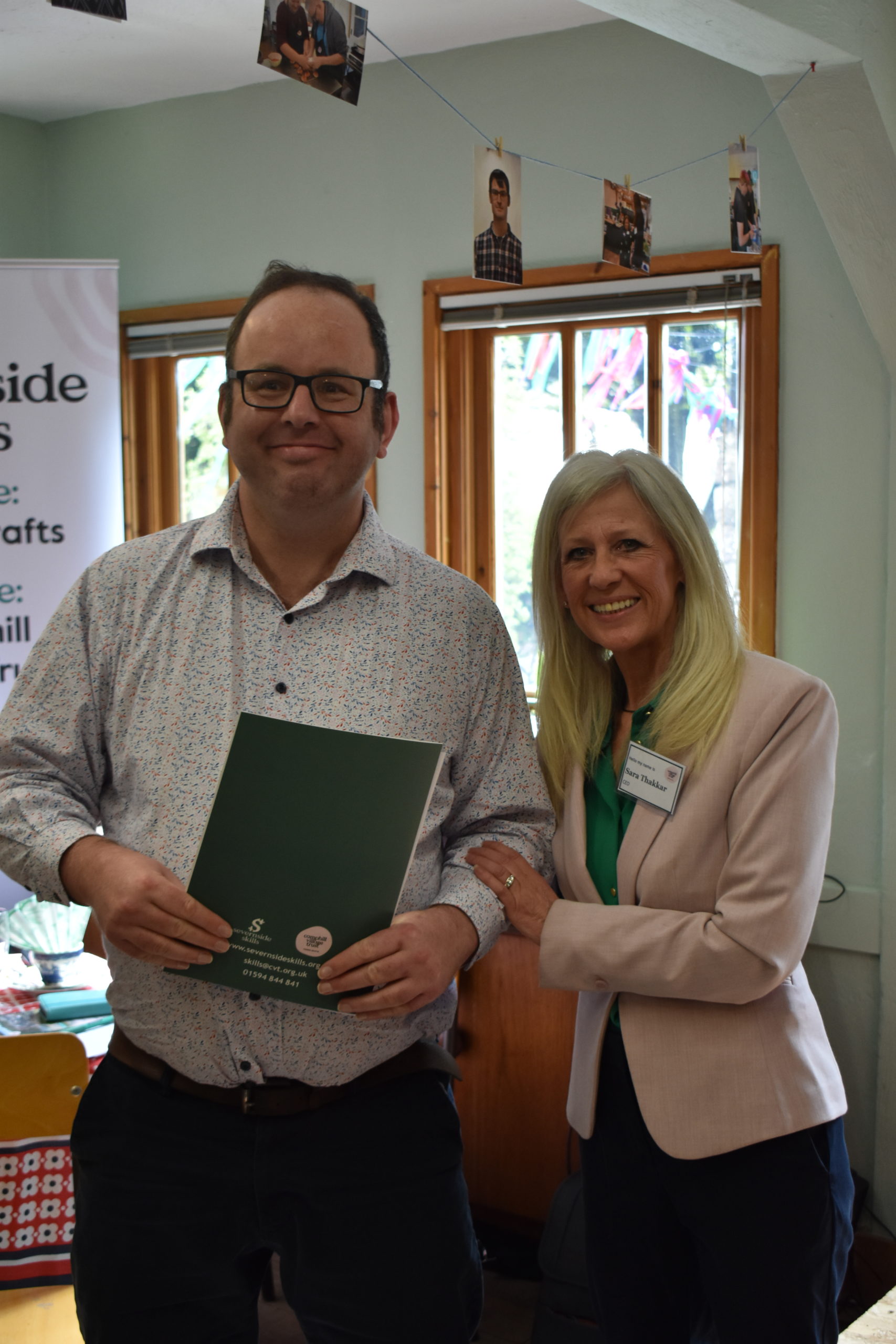 Sara Thakkar standing with a man at Severnside Skills graduation at Taurus Crafts, Camphill Village Trust