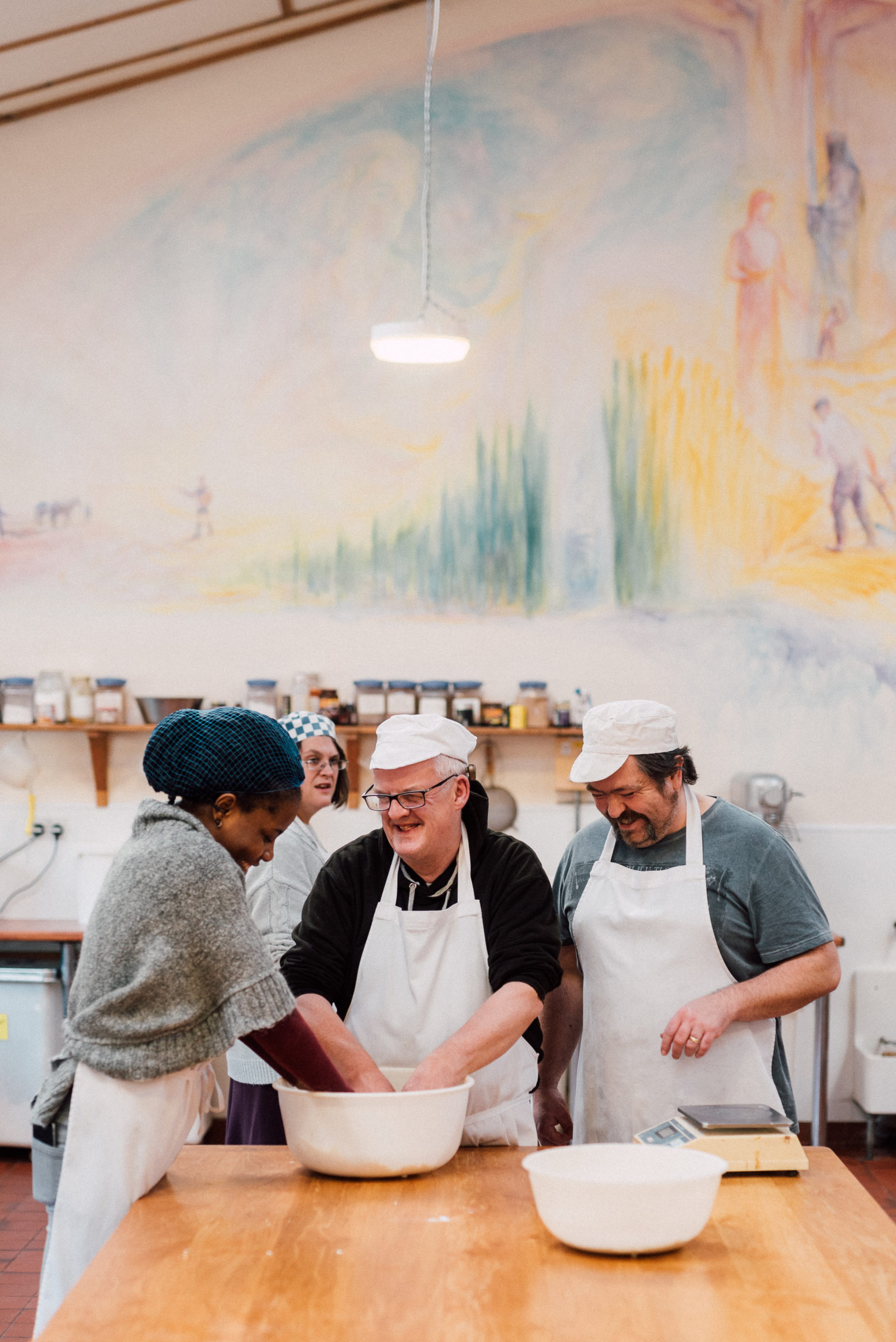 3 people cooking together in a kitchen laughing