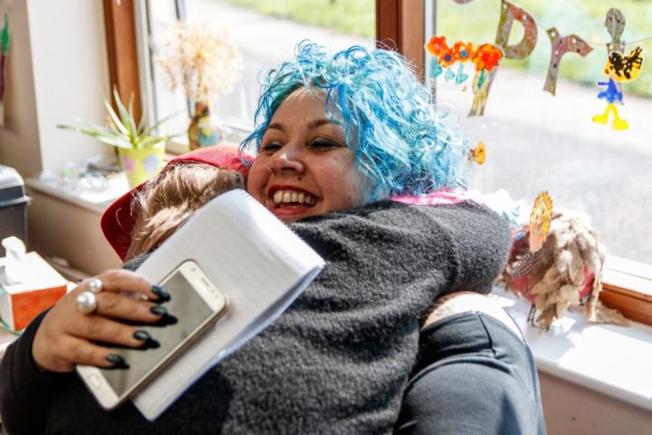 A staff member hugging a community member, smiling