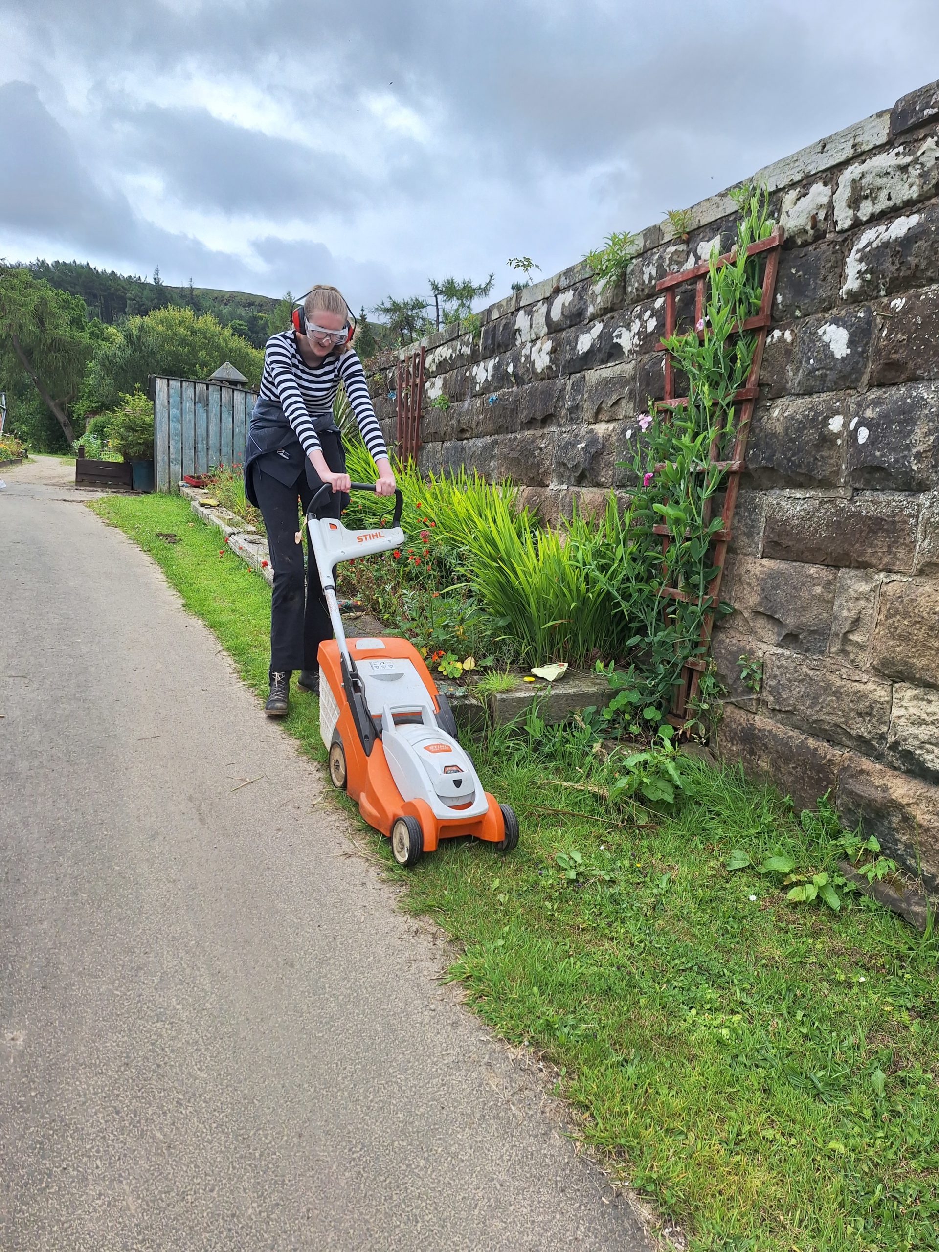 A person we support mowing the lawn 