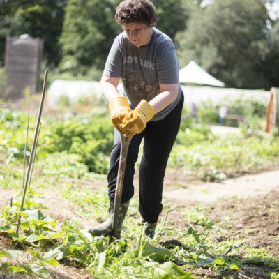 One of the people we support gardening outside, digging with a spade