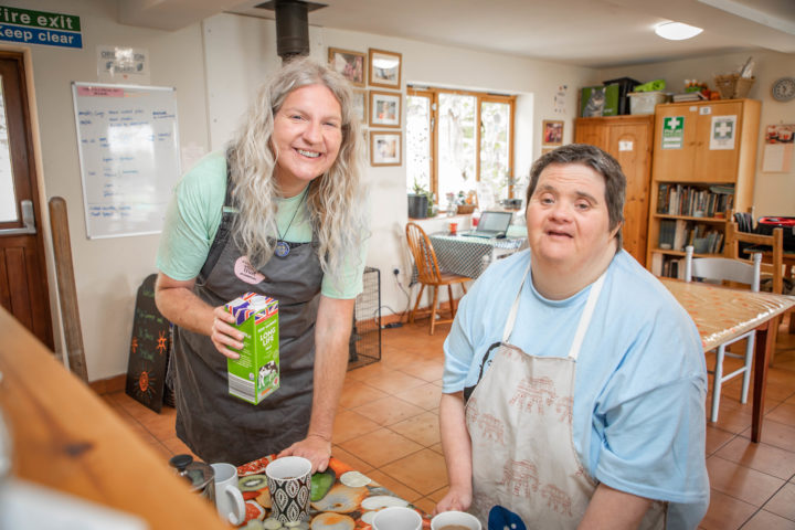 A support worker and person we support making teas and coffees in the kitchen