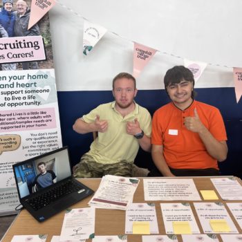 2 people sitting at a table at an event