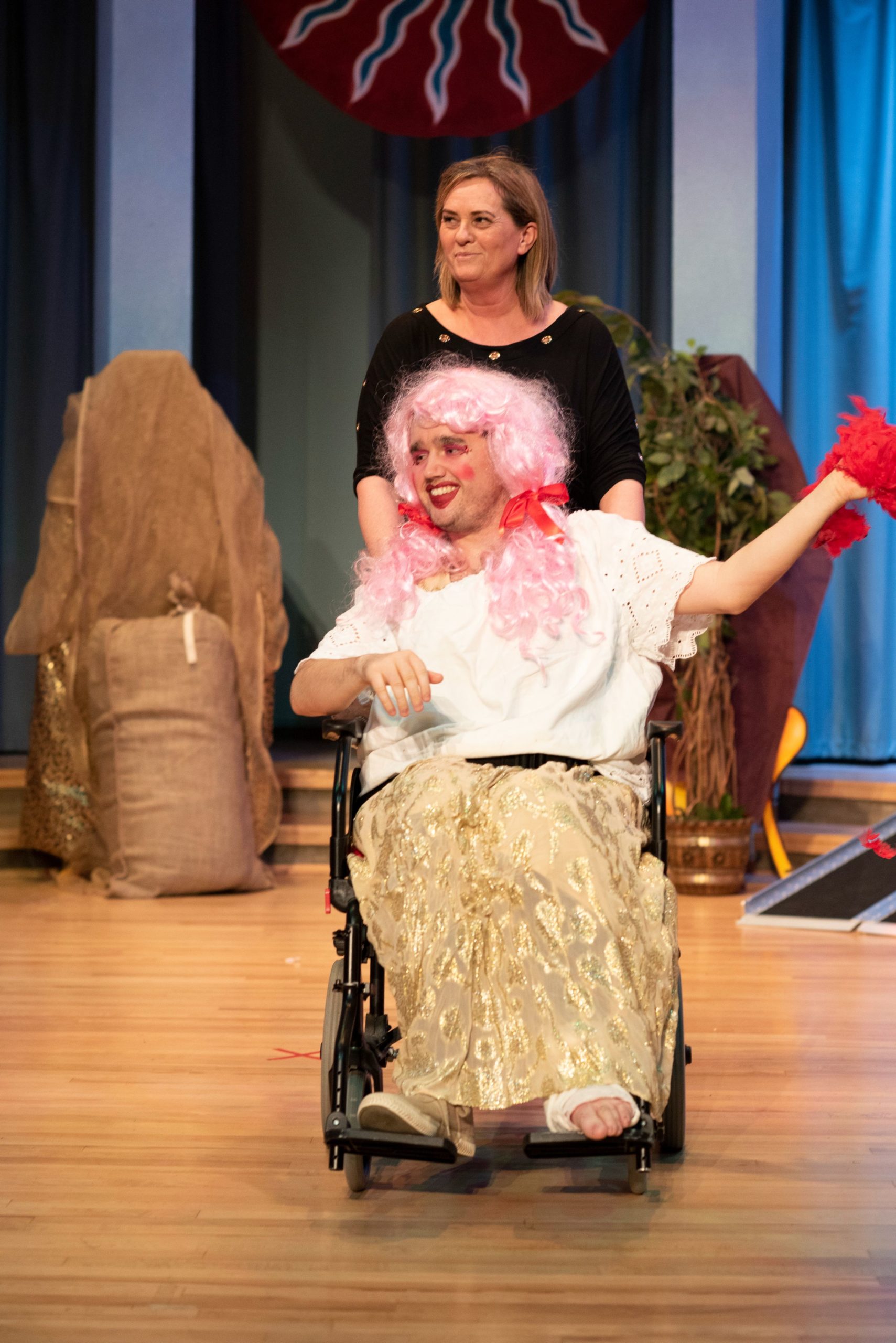 One of the people we support acting in a play wearing a costume sitting in a wheelchair