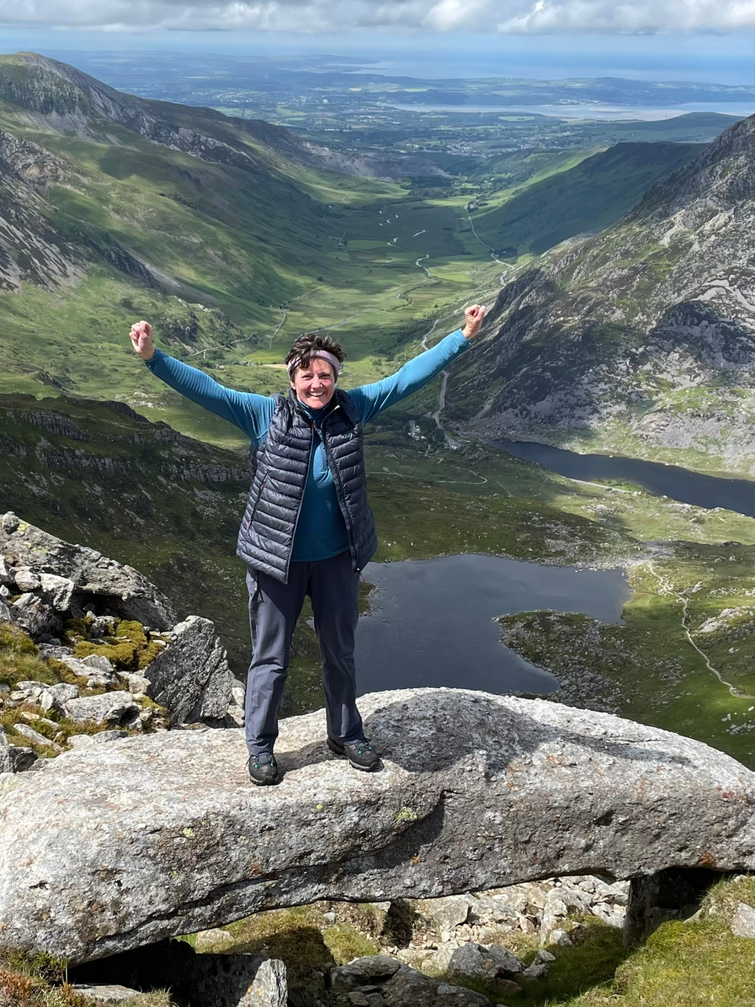 Our Director, Claire, standing on top of a mountain