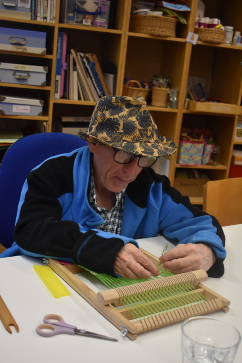 A person we support making leaves in an arts and crafts workshops