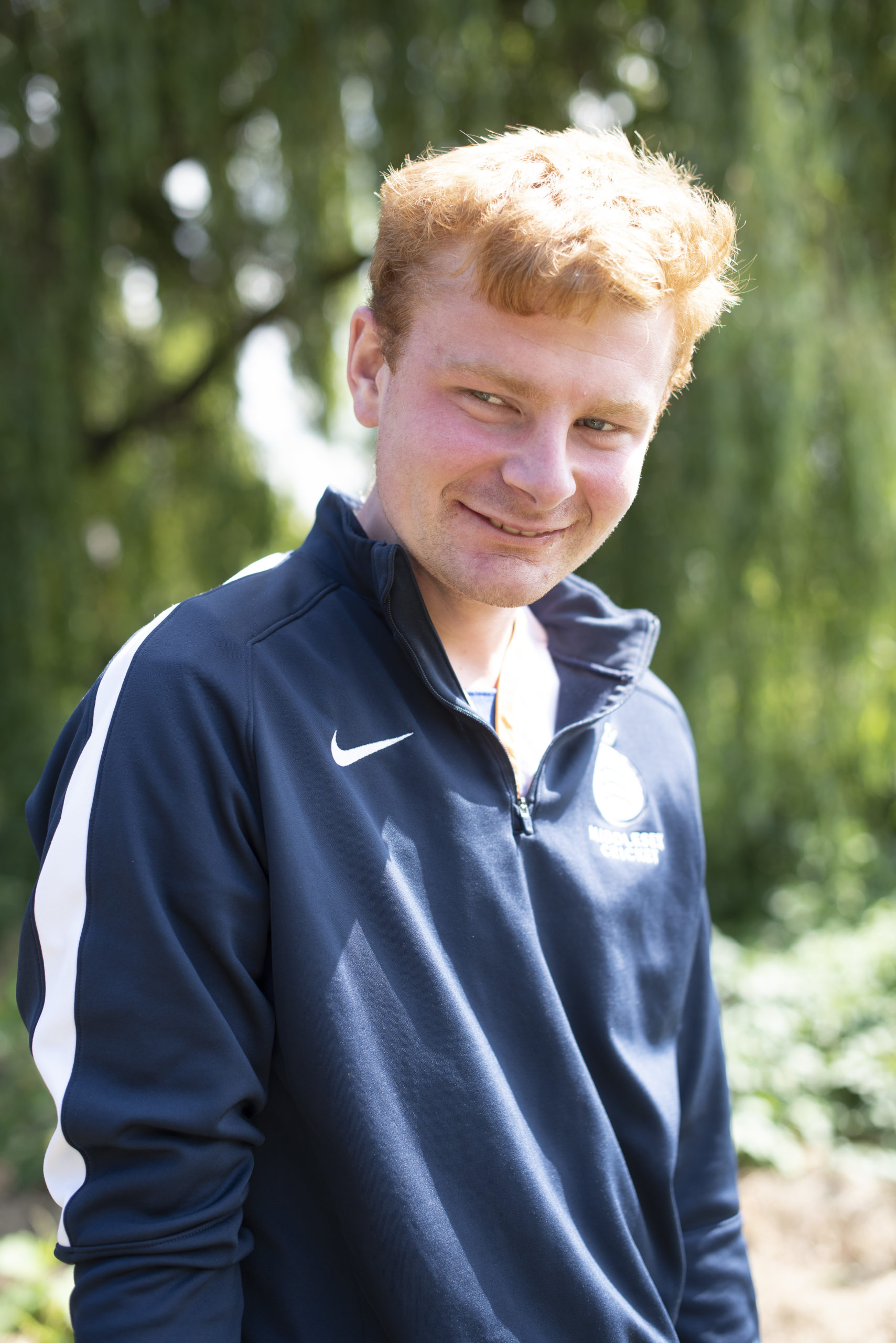 A person we support smiling while standing outside