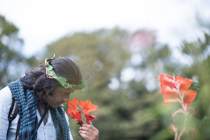 A person we support smelling an orange flower