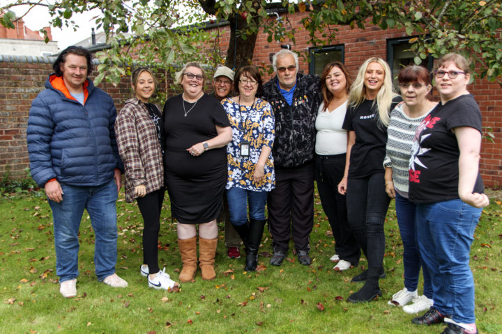 Staff and people we support standing together smiling