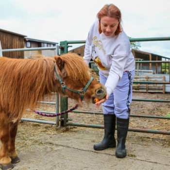 A person we support feeding a pony