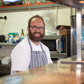 A person we support smiling in the kitchen