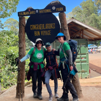 Our team standing in front of a Congratulations sign post-hike