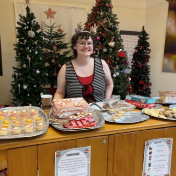 Amy, craft workshop lead, Larchfield community, sitting at a Christmas stall