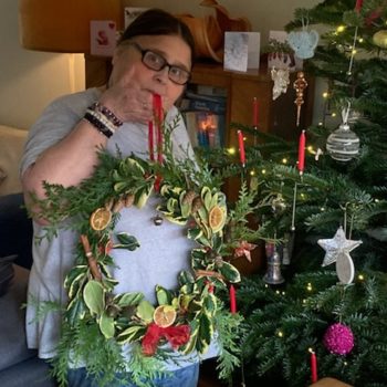 Sandy holding a wreath she made by hand