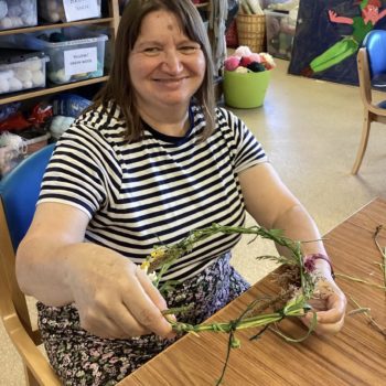 Community members in a craft workshop making flower headbands in Larchfield