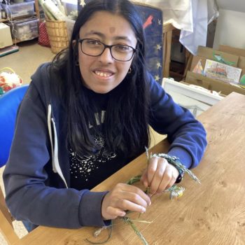 Community members in a craft workshop making flower headbands in Larchfield